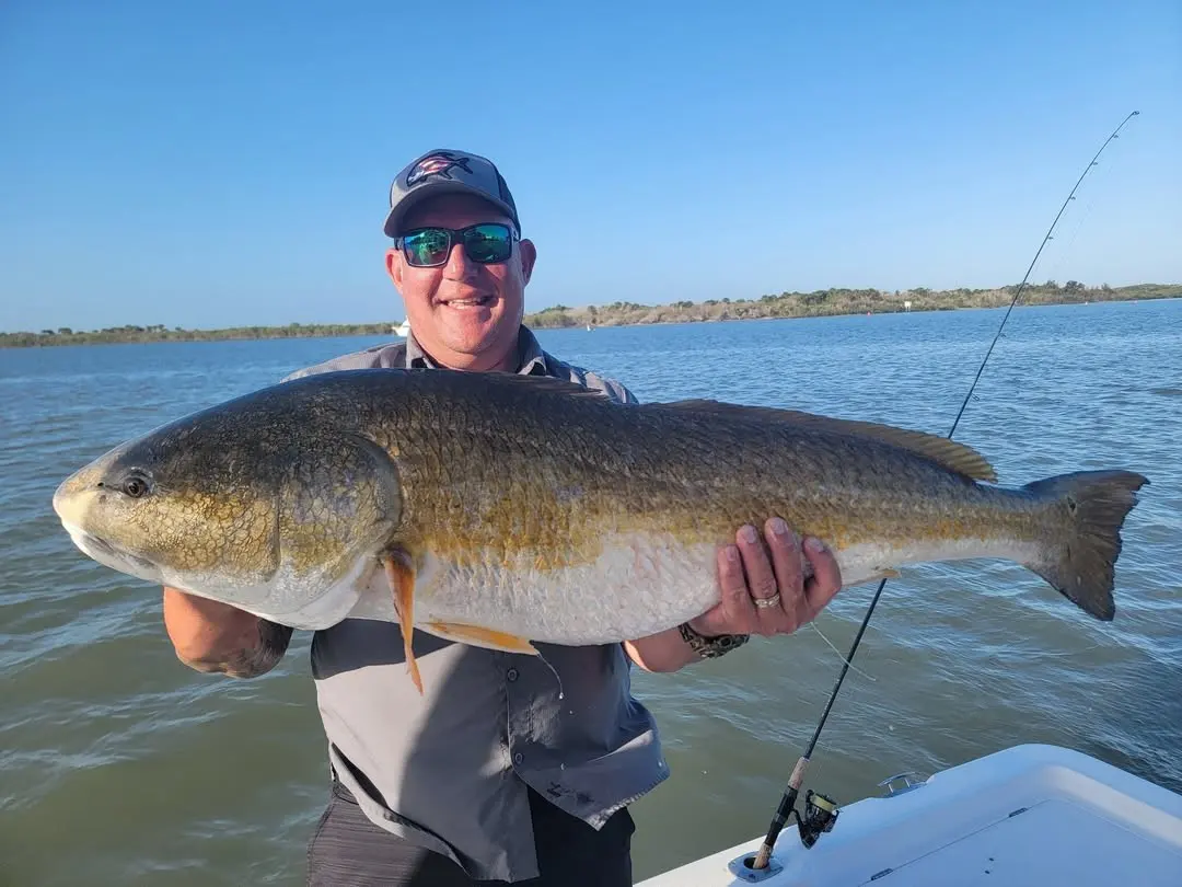 Bull redfish held up by a happy angler