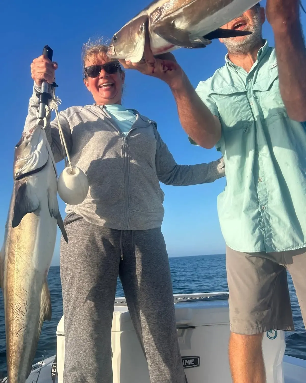Two anglers showing off their catch
