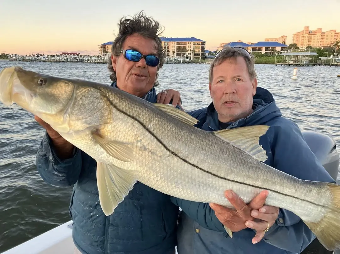 Big snook at sunset with the Daytona skyline behind