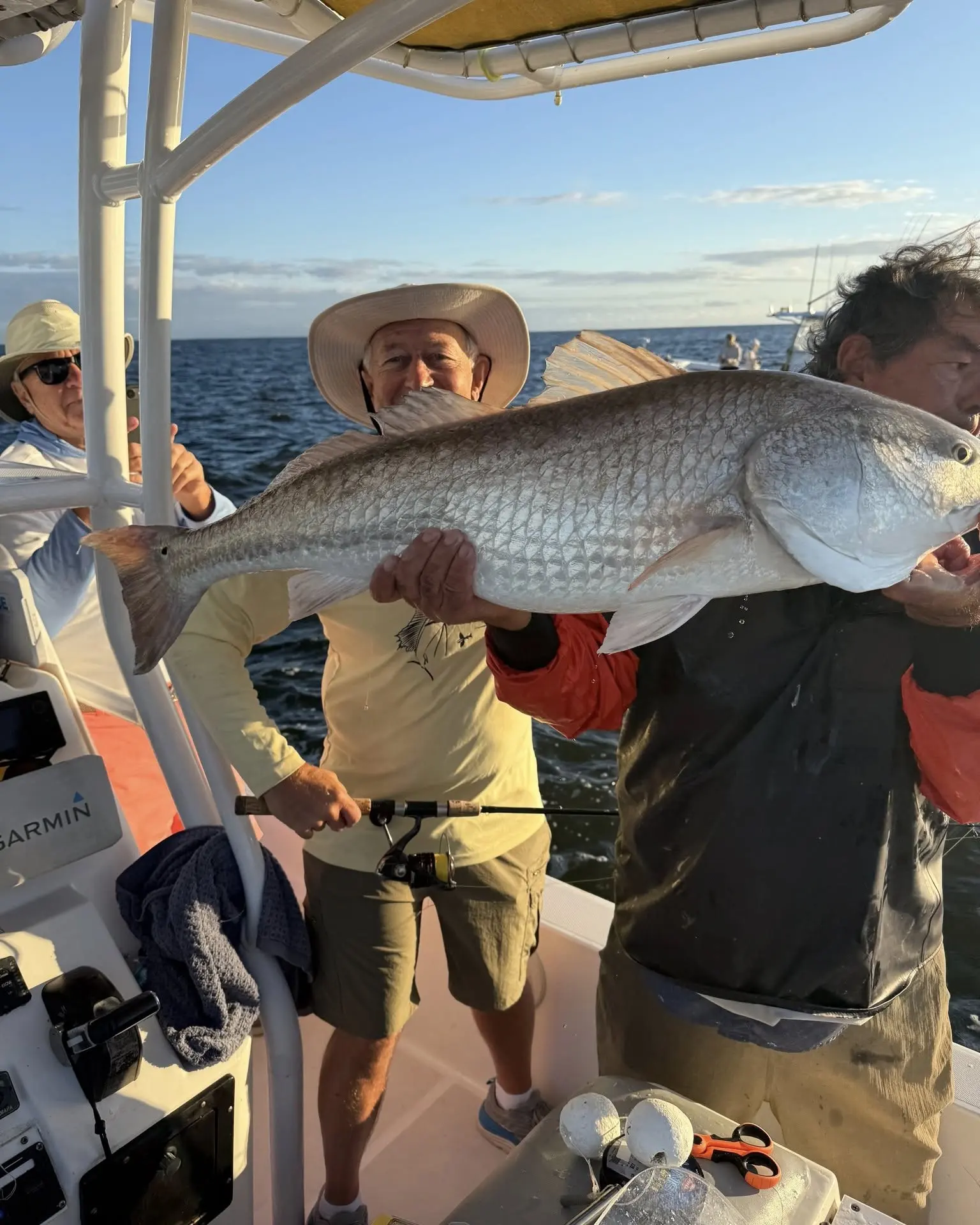 Two anglers with a redfish under the T-top