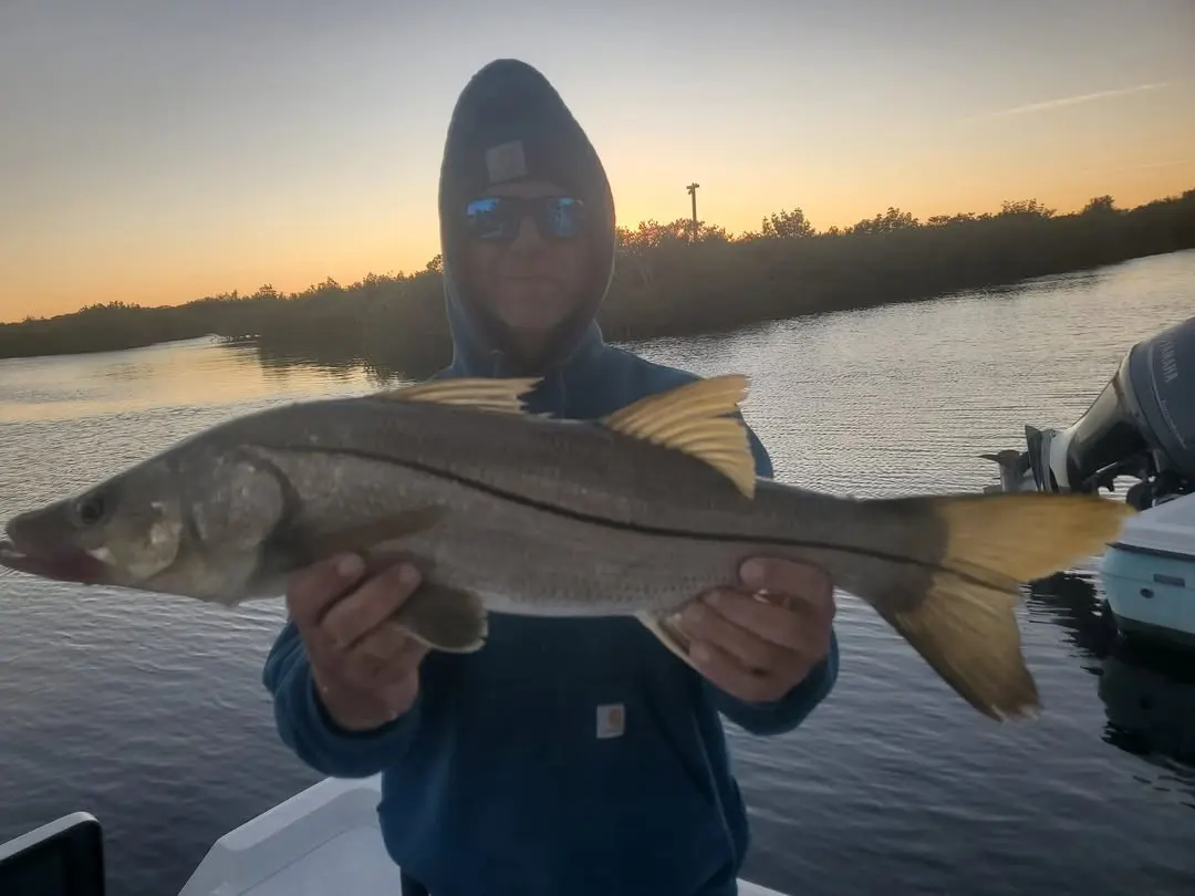 Angler with a snook at sunset
