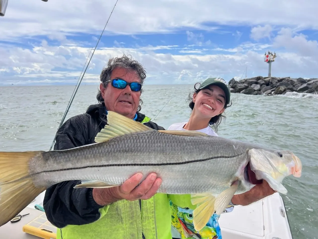 A family holding up redfish on a calm morning in Mosquito Lagoon